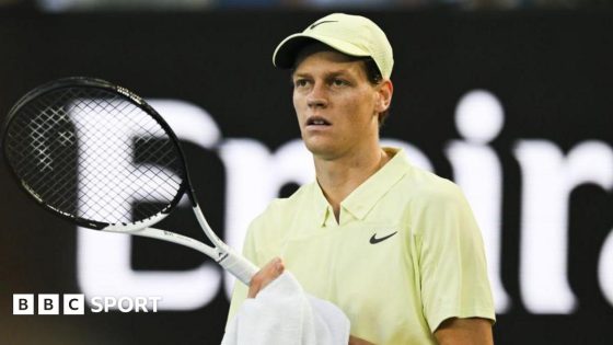 Jannik Sinner wiping his racquet with a towel during a match