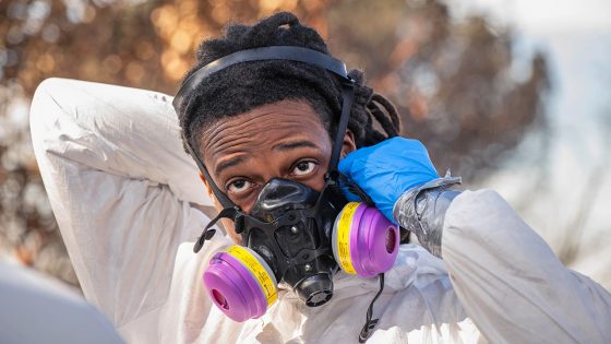 An Environmental Protection Agency contractor puts on a respirator during Phase 1 of debris removal in LA.