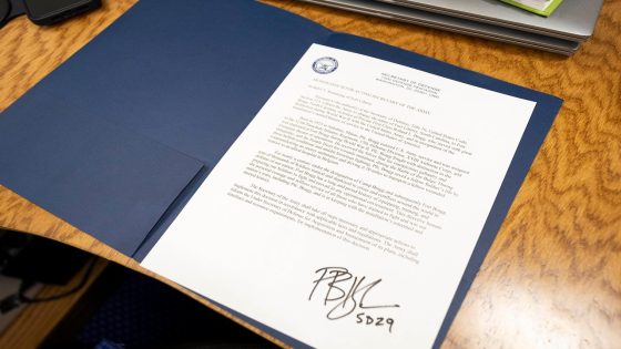 A signed memorandum is seen atop an open blue folder.