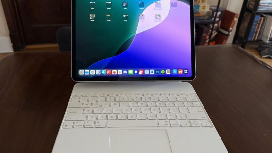 An iPad is attached to a keyboard and sits on a wooden table