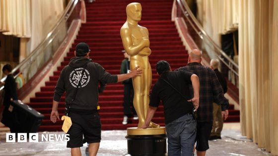 Workers transport an Oscar statue on the red carpet during preparations for the 97th annual Academy Awards ceremony at the Dolby Theatre at Ovation Hollywood in Los Angeles, California