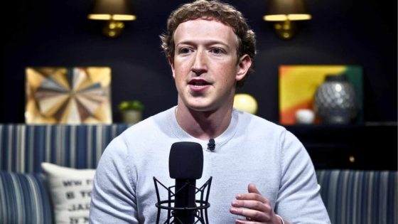 Mark Zuckerberg With Curly Hair, Wearing A White Sweater, Speaking Into A Black Microphone