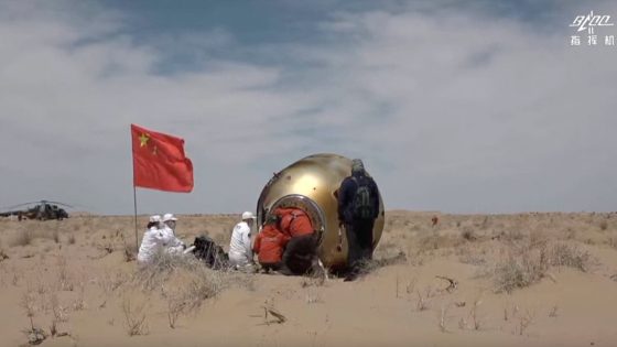 a golden space capsule descends through a blue sky beneath a large, red-and-white-striped parachute