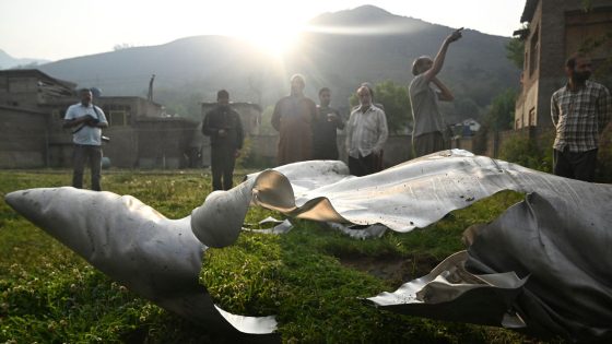 People look at a part of an aircraft in Wuyan near Indian-administered Kashmir's main city of Srinagar