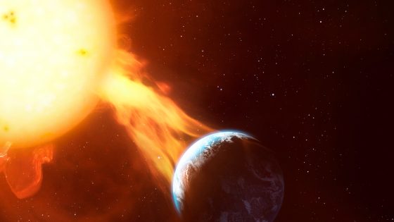 a fiery star sends out a tendril of flame towards a blue and white planet