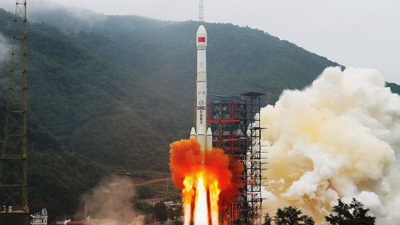 a white rocket launches into a cloudy sky with forested mountains in the background