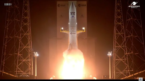 a big white rocket launches into a dark night sky