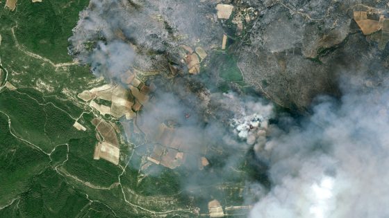 fire and smoke rolls through a green countryside as seen from space 