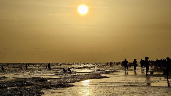 People walk on the beach at sunset at Siesta Beach in Sarasota, Florida, on June 6, 2025. At least 13 cases of Vibrio vulnificus infections have been reported in the state this summer, with four resulting in death.